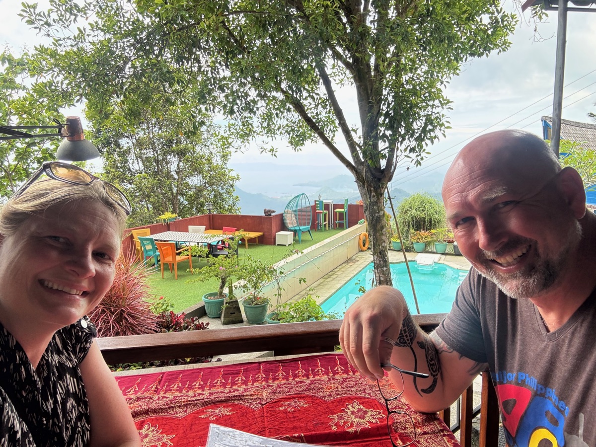 Katrin und Carsten sitzen gemeinsam auf einer offenen Terrasse mit Blick ins Grüne.